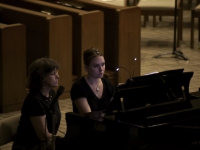 Accompanist and her page turner sit at the piano