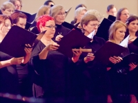 Chorus members study their music during pre-concert sound check