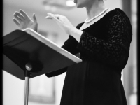 Black and white photo looking up at Jenn as she conducts the chorus