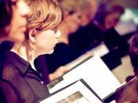 Chorus members looking up from music during a concert